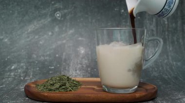 Buzlu Hojicha Latte, evde demlenmiş, Japon çayı, kavrulmuş yeşil çay yaprakları.