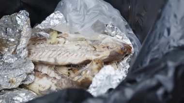 Yiyecek atıkları, yakın çekim, yemek artıkları, çöp kutusunda ızgara siyah bantlı kral balığı..
