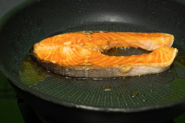 Somon, siyah demir bir tavada kızartılıyor..