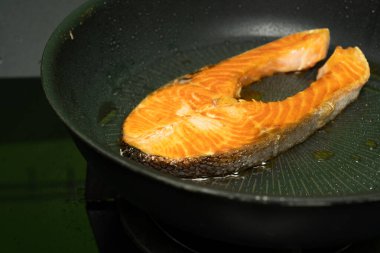 Somon, siyah demir bir tavada kızartılıyor..