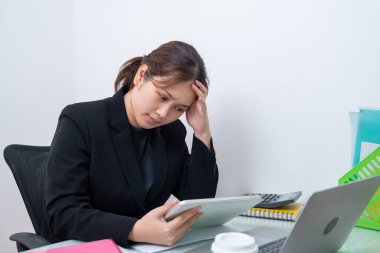 Ofisteki dijital tabletteki verilere bakan Asyalı iş kadını muhasebe numaraları üzerinde duruyor. Muhasebeci, girişimci ve yönetici..