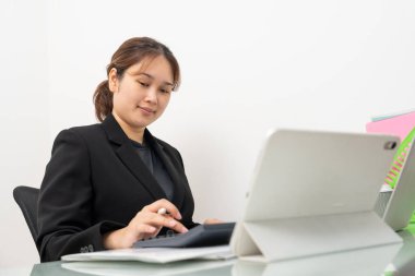 Dizüstü bilgisayarda çalışan Asyalı iş kadını, ofiste mali belge raporlarını okuyor. Muhasebeci, girişimci, menajer. İş kadını dizüstü bilgisayarla belge hazırlıyor.