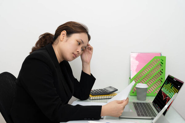 Азиатская деловая женщина, работающая над цифровым талбетом, читающая финансовый отчет, чувствующая себя серьезной или напряженной из-за низких показателей доходов. Бухгалтер, предприниматель, менеджер.