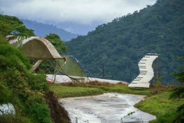 Terk edilmiş dağlık sera. Tepedeki kır yolu
