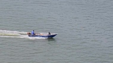Deniz yüzeyinde yüzen bir balıkçı teknesi. Okyanusta küçük dalgalarla Hız teknesinin üzerinden uçan uçak vuruldu. Hızlı sürat teknesi suda ilerliyor.