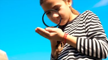 Çocuk toprağı bir büyüteçle inceliyor. Seçici odaklanma. Çocuk.