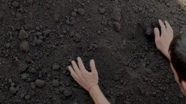Adam toprağı elinde tutuyor. Seçici odaklanma. Doğa.