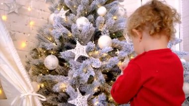 Çocuk Noel ağacına bir süs astı. Seçici odaklanma. Tatil.