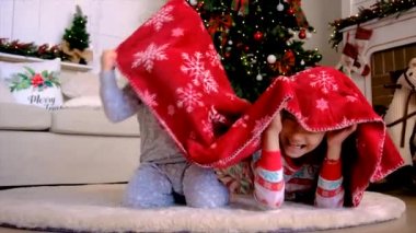 Çocuklar ağacın altında bir battaniyeyle oynarlar. Seçici odaklanma. Tatil.