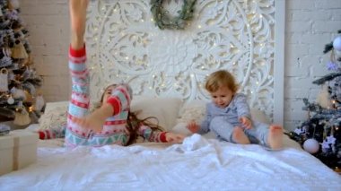 Çocuklar Noel ağacının altındaki yatağa atlarlar. Seçici odaklanma. Çocuk.