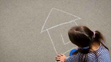 Çocuk kaldırıma tebeşirle çiziyor. Seçici odaklanma. Çocuk.