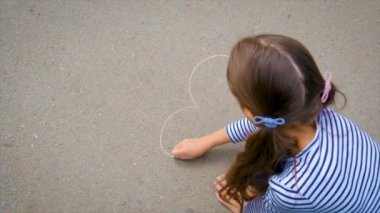 Çocuk kaldırıma tebeşirle çiziyor. Seçici odaklanma. Çocuk.