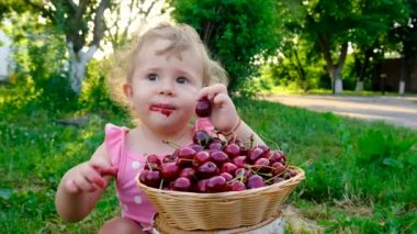 Çocuk bahçede kiraz yiyor. Seçici odaklanma. Çocuk.