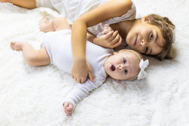 Küçük kız kardeşler battaniyeye uzanıyorlar. Seçici odaklanma. çocuk.