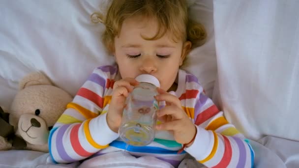 Bebê Beber Água Uma Garrafa Cama Foco Seletivo Miúdo — Vídeo de Stock