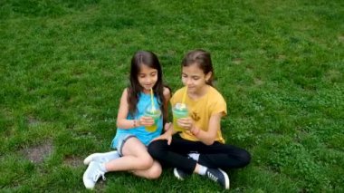 Parktaki çocuklar soğuk bir kokteyl içerler. Seçici odaklanma. Çocuklar.
