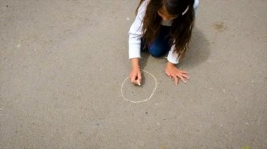 Çocuk kaldırıma tebeşirle çiziyor. Seçici odaklanma. Çocuk.