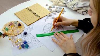 Woman astrologer draws a natal chart. Selective focus. People.
