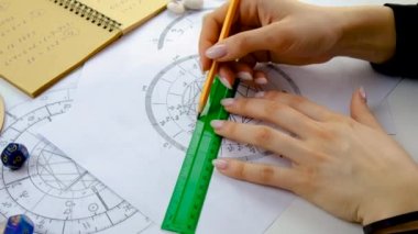 Woman astrologer draws a natal chart. Selective focus. People.