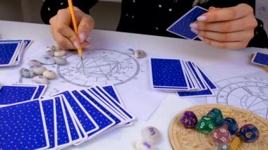 Woman astrologer draws a natal chart. Selective focus. People.