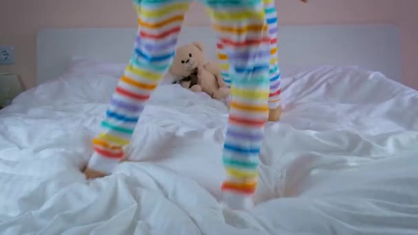 子供はベッドの上で枕にふける 選択的集中 子供よ — ストック動画