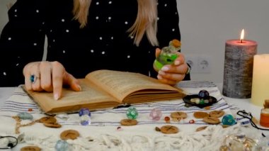Woman fortune teller reads a book of spells. Selective focus. People.