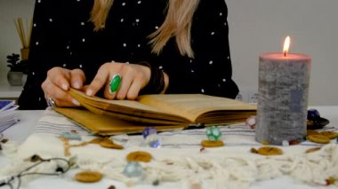 Woman fortune teller reads a book of spells. Selective focus. People.