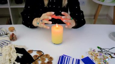 Woman fortune teller fortune telling on a candle. Selective focus. people.