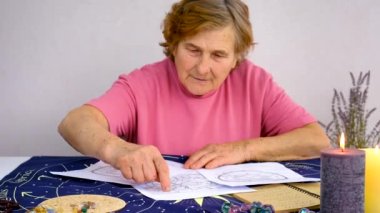 Woman astrologer draws a natal chart. Selective focus. People.