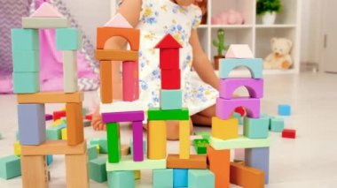 The child plays in the childrens room with a wooden constructor. Selective focus. Kid.