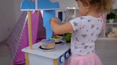 the child plays in the kitchen and cooks. Selective focus. Kid.