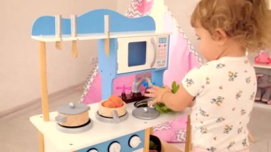 the child plays in the kitchen and cooks. Selective focus. Kid.