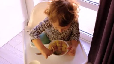 The child eats the soup from the plate. Selective focus. Kid.
