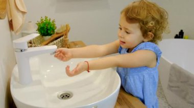 Çocuk ellerini sabun ve suyla yıkar. Seçici odaklanma. Çocuk.