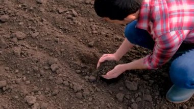 Tarladaki erkek çiftçi toprağı kontrol ediyor. Seçici odaklanma. Doğa.