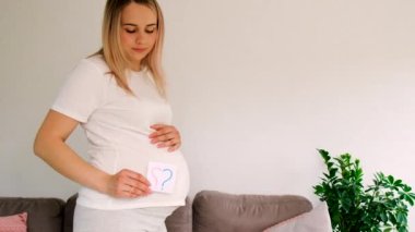 Soru işareti olacak hamile bir kadın var. Seçici odaklanma. Şirin..