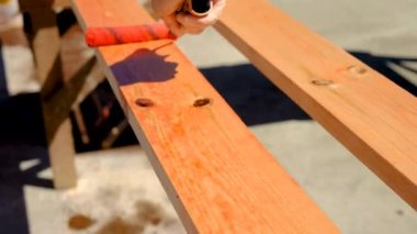 Kırmızı antiseptikle ahşap tedavisi. Seçici odaklanma. Doğa.