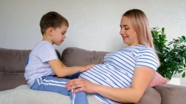 Hamile bir kadın en büyük oğluna sarılır. Seçici odaklanma. Aşk.