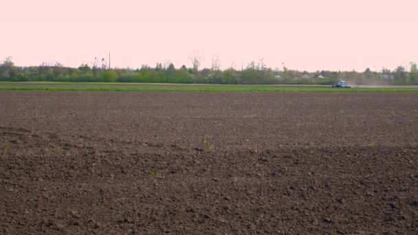 畑のトラクターが土を耕す 選択的フォーカス — ストック動画