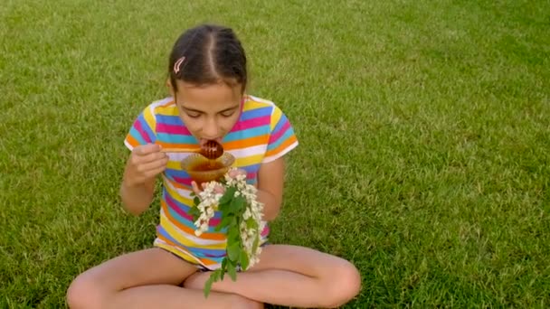 Ein Kind Isst Honig Von Einer Akazie Garten Selektiver Fokus — Stockvideo
