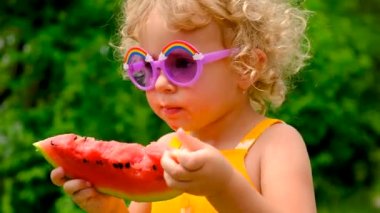 The child eats watermelon in summer. Selective focus. Kid.
