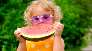 The child eats watermelon in summer. Selective focus. Kid.