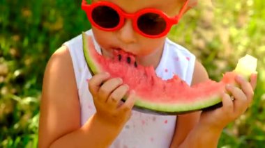 The child eats watermelon in summer. Selective focus. Kid.