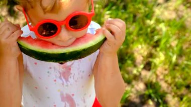The child eats watermelon in summer. Selective focus. Kid.