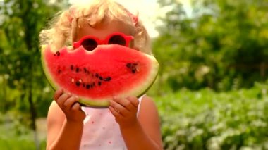 The child eats watermelon in summer. Selective focus. Kid.