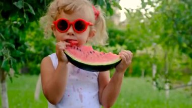 The child eats watermelon in summer. Selective focus. Kid.