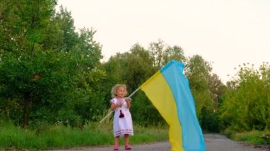Üzerinde Ukrayna bayrağı olan nakışlı gömlekli bir çocuk. Seçici odaklanma. Doğa.