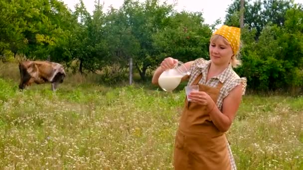 女人把牛奶倒在农场上 有选择的重点 — 图库视频影像