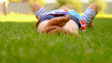 Parktaki çimlerin üzerinde çocuk ayakları. Seçici odaklanma. Çocuk.