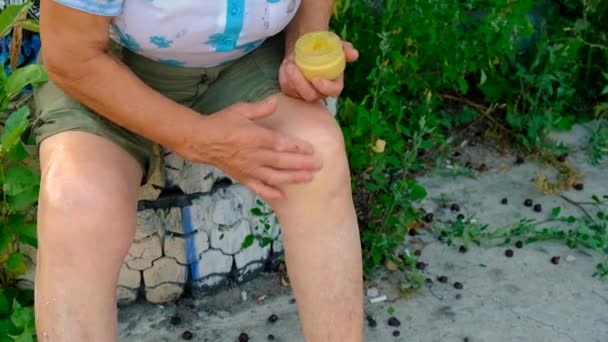 古い女性は膝に代わる治療法を適用する 選択的な焦点 — ストック動画